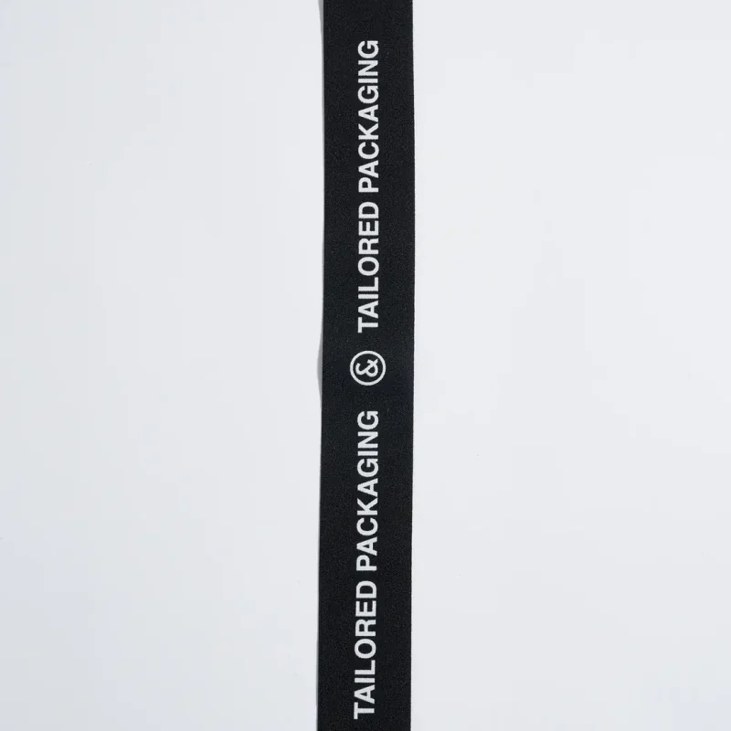 dettaglio-del-nastro-con-logo-co&in-bianco-su-tessuto-nero