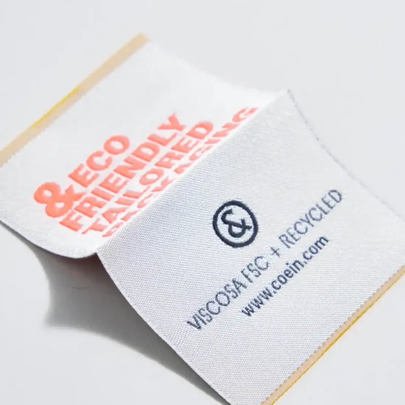 Etichetta tessuta a cavallotto con fondo in viscosa FSC e broccato in poliestere